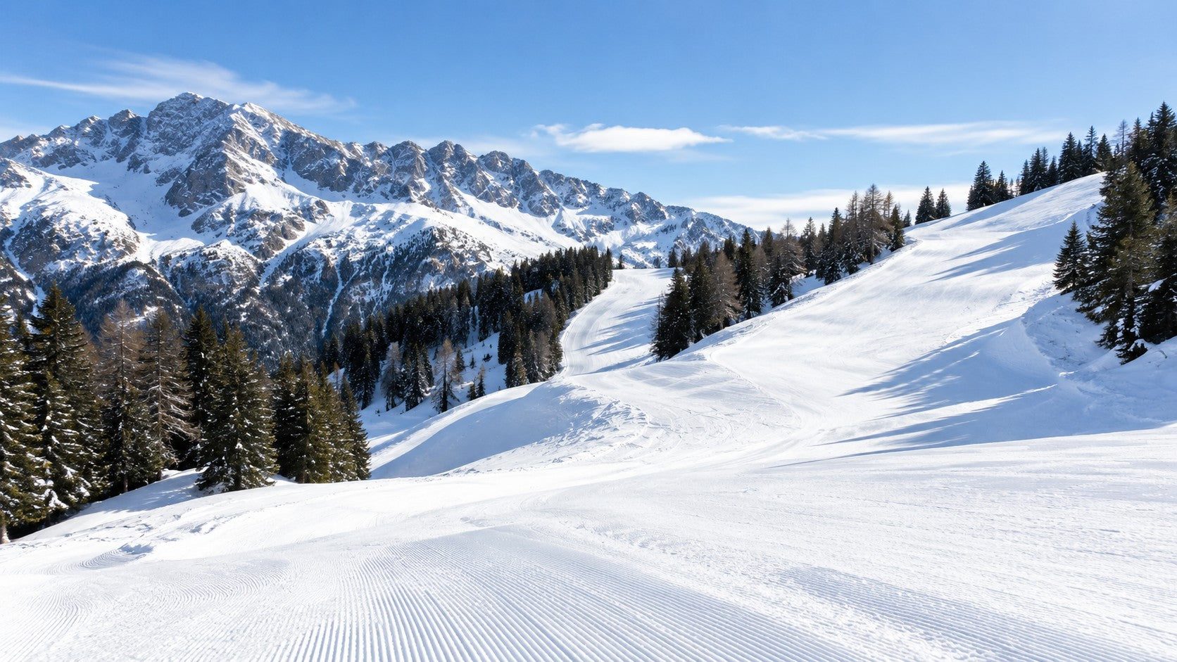 Sunny groomed ski slope in the mountains